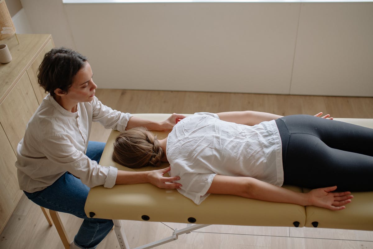 Therapist guiding a patient on the treatment table